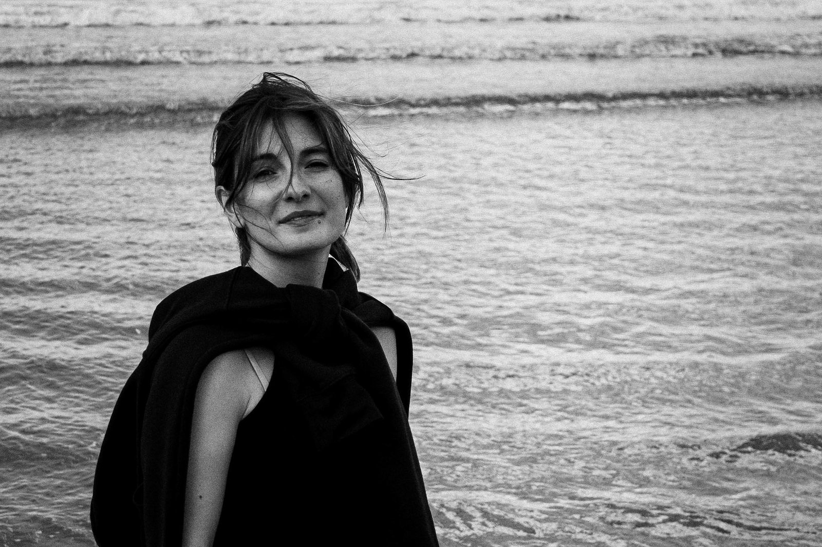 Una donna sorride in riva al mare