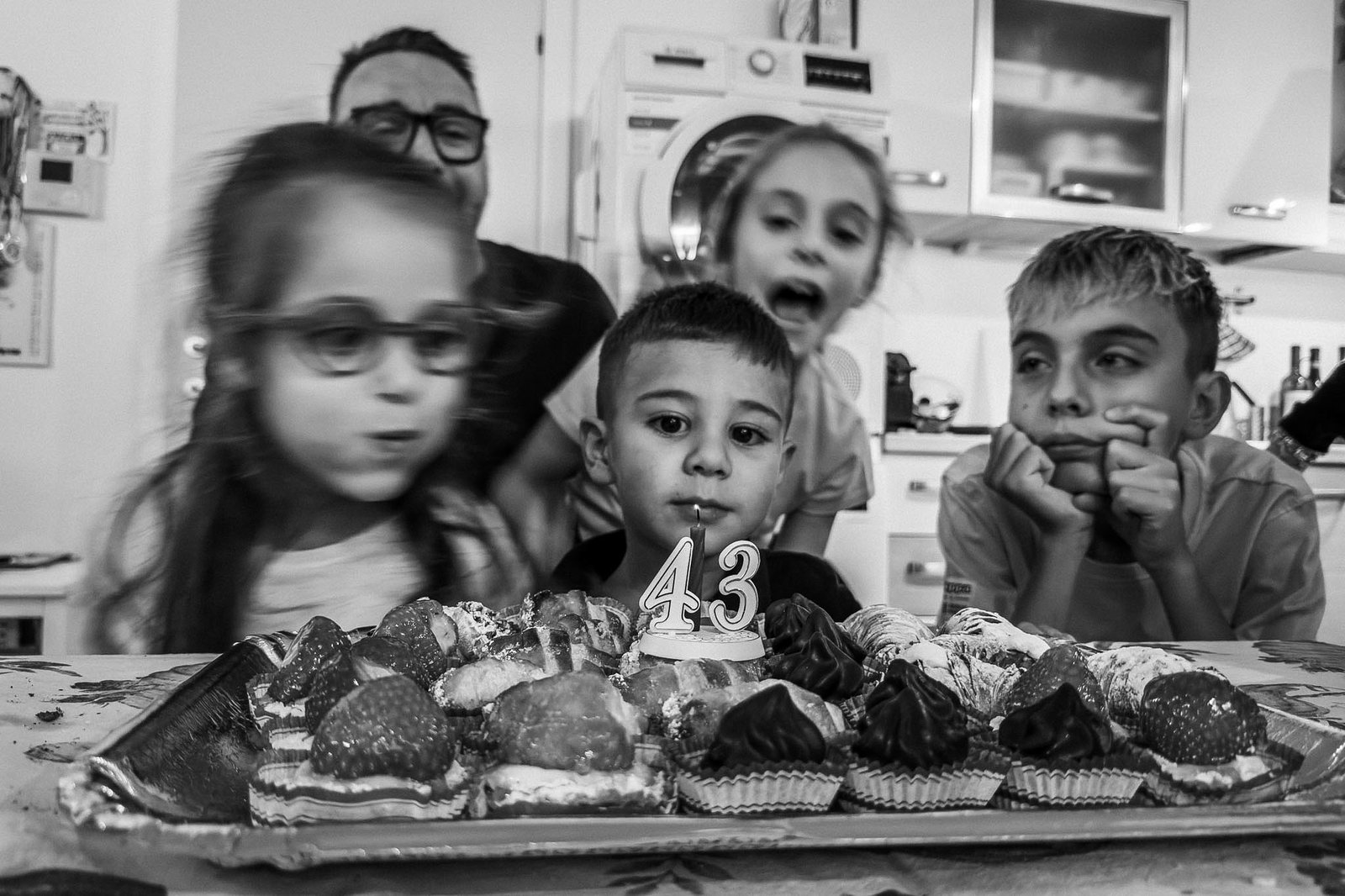 Bambini intorno a un tavolo di dolcetti a una festa