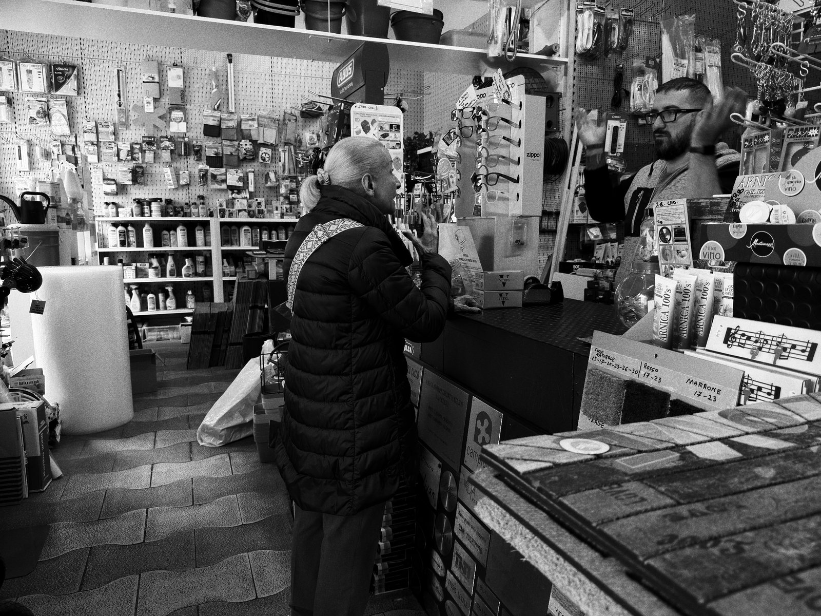Un'anziana al bancone di un negozio pieno di oggetti
