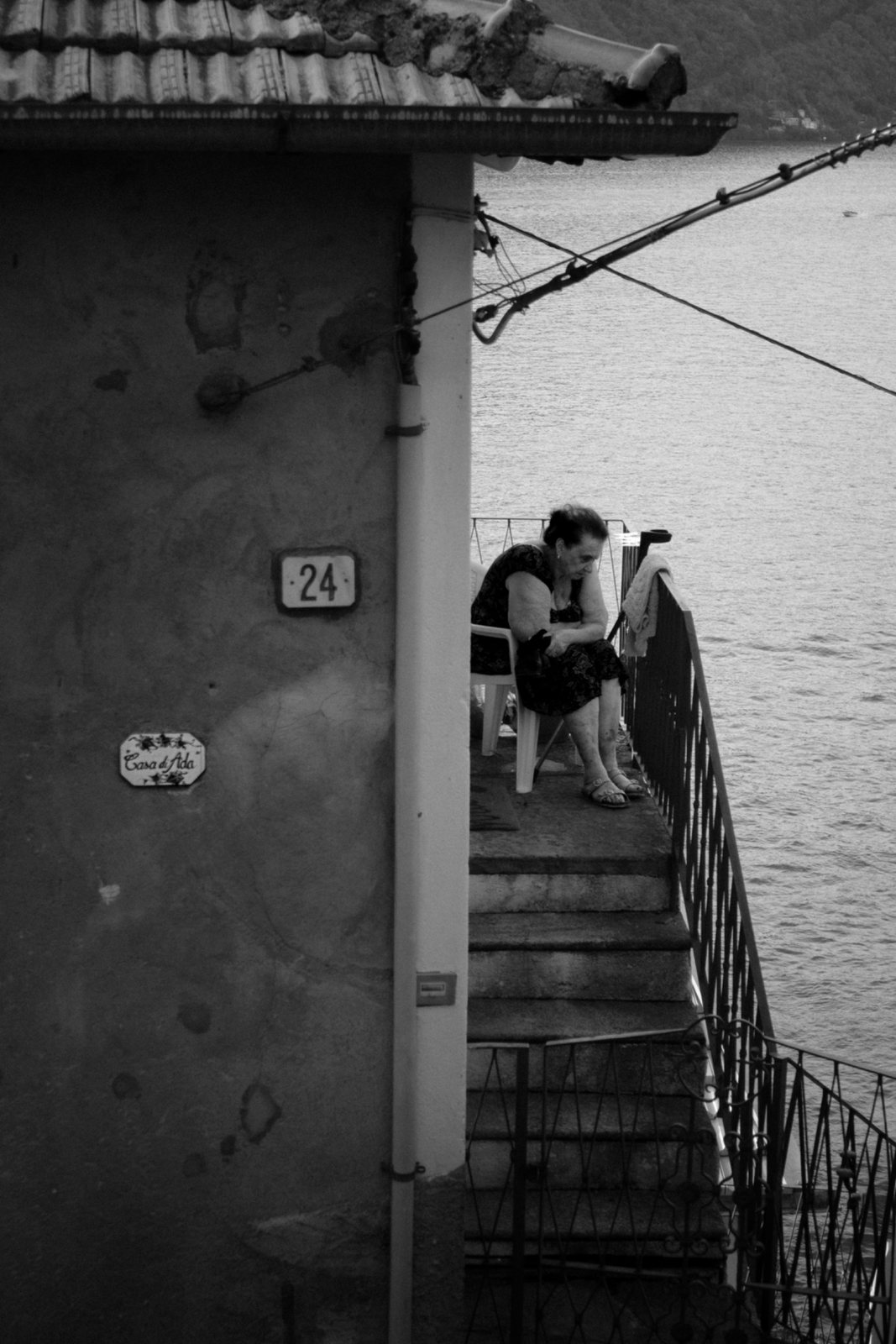 Una donna seduta su una scala che scende all'acqua
