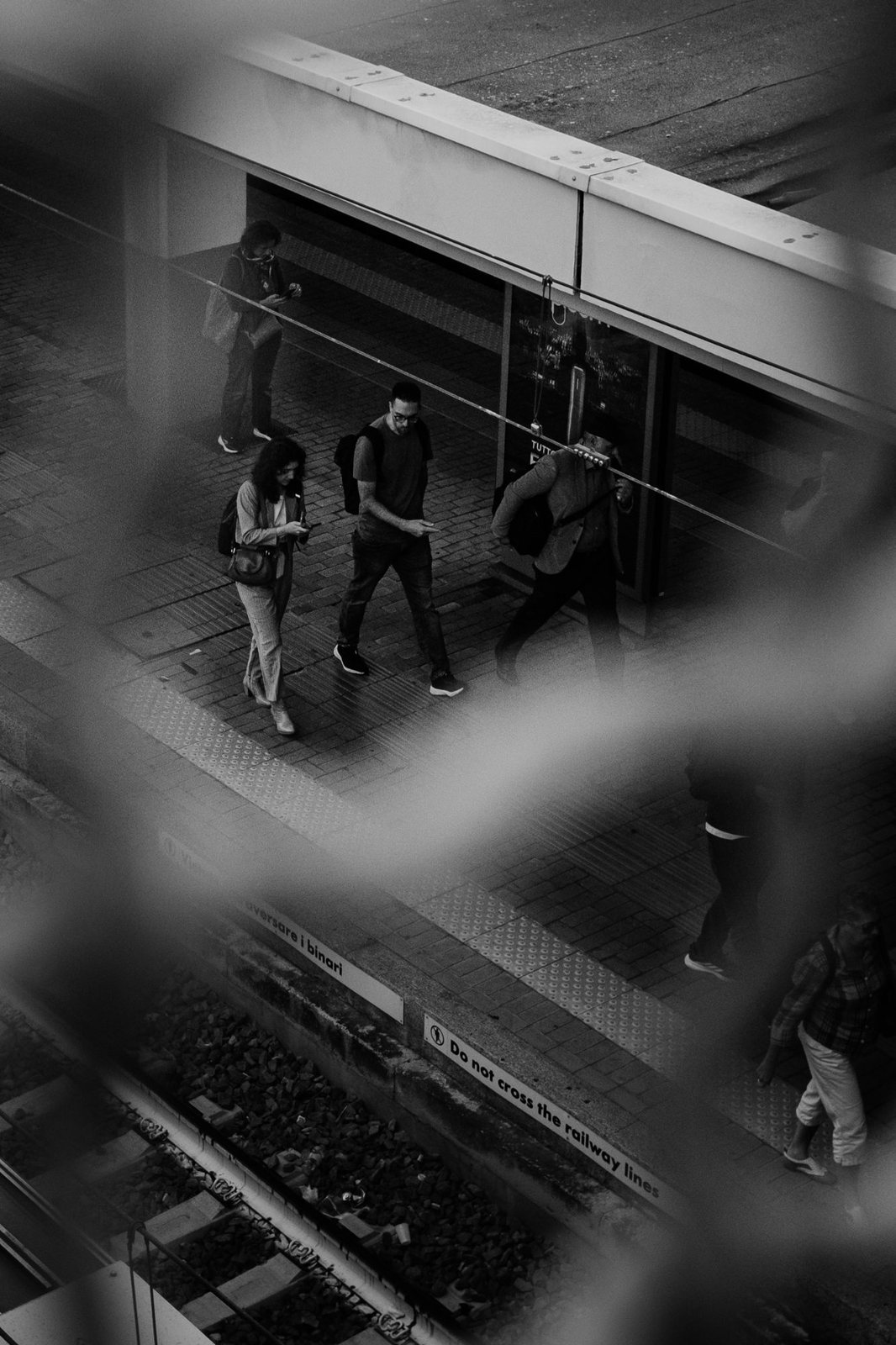Persone sulla banchina viste attraverso una rete